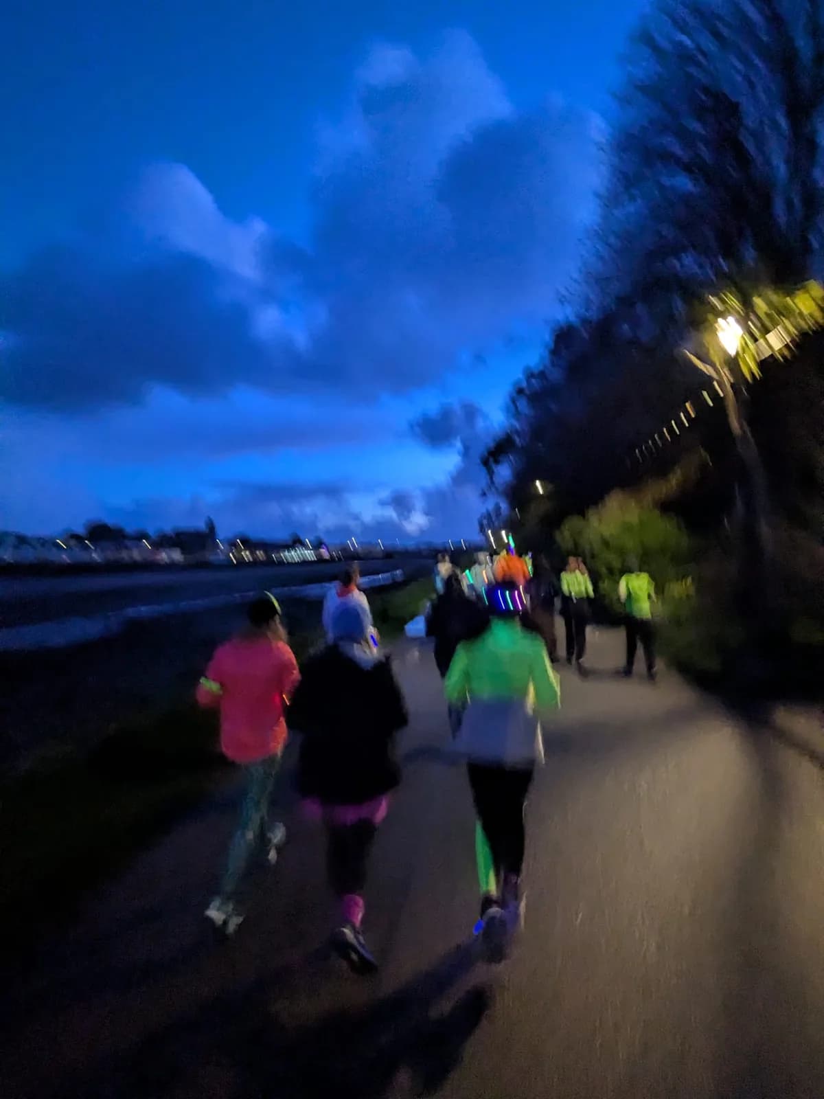 Runners strung out along the seafront in fading light